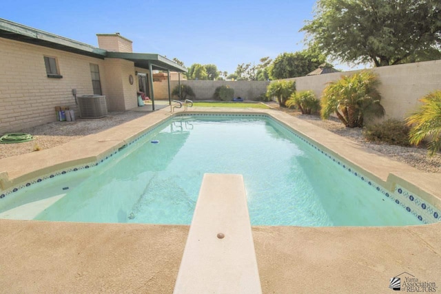 view of pool featuring central AC unit, a patio, and a diving board