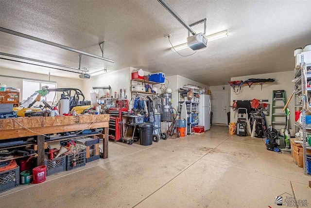 garage with white refrigerator and a garage door opener