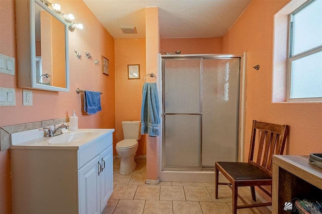 bathroom featuring walk in shower, vanity, a textured ceiling, tile patterned flooring, and toilet