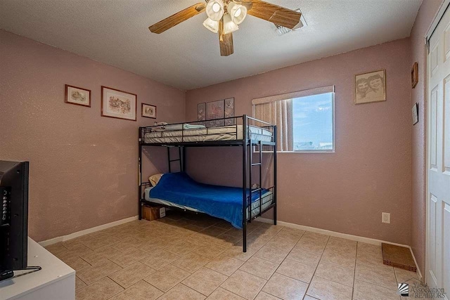 bedroom with a textured ceiling and ceiling fan