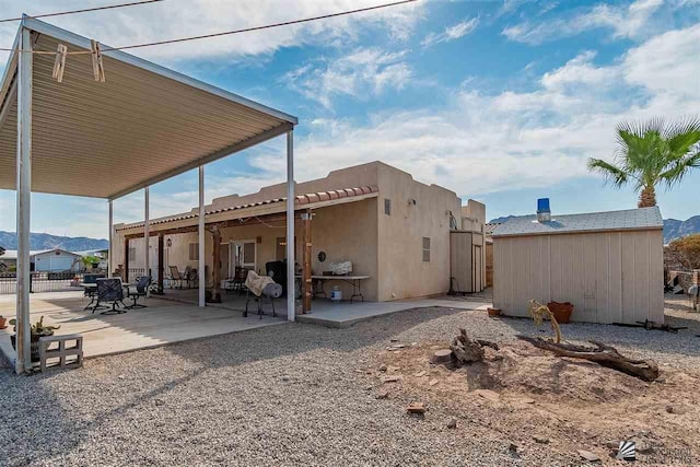 back of property featuring a patio area and a mountain view