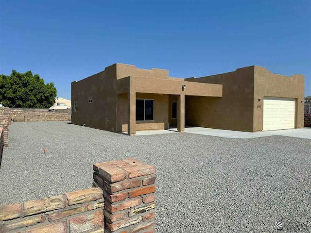 pueblo revival-style home with a garage