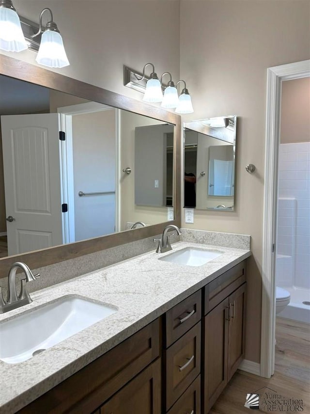 bathroom with walk in shower, vanity, toilet, and hardwood / wood-style flooring