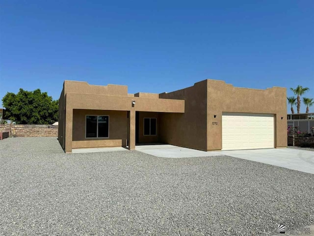 pueblo revival-style home featuring a garage