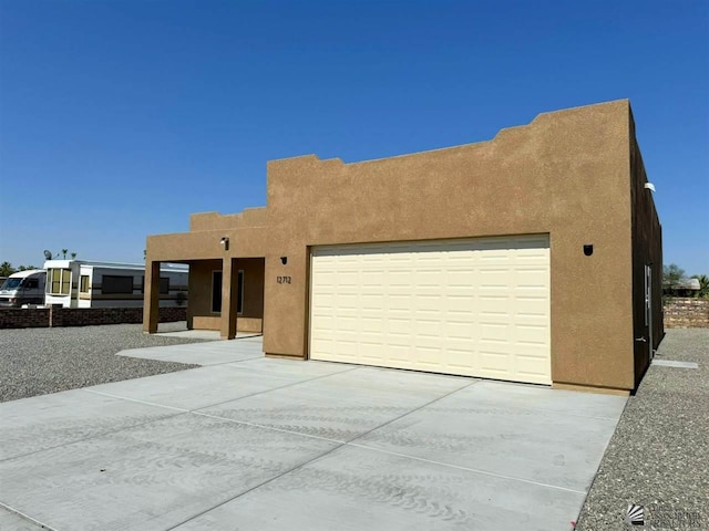 pueblo revival-style home featuring a garage