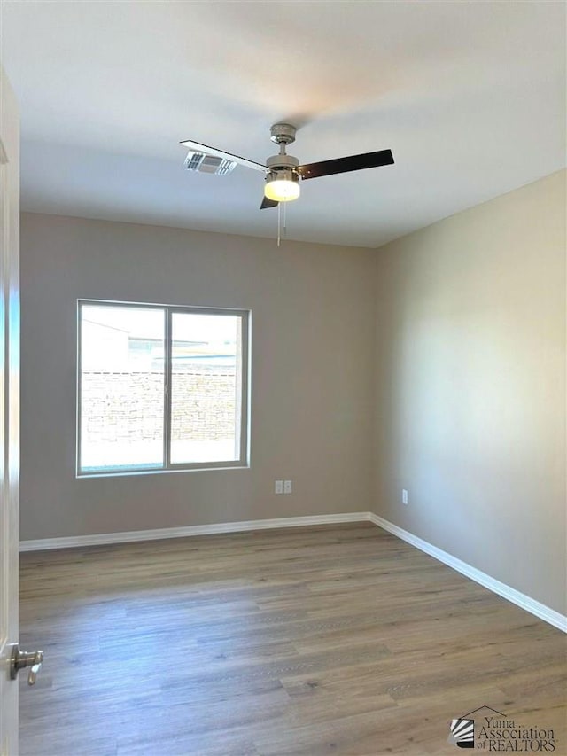 empty room featuring hardwood / wood-style flooring and ceiling fan