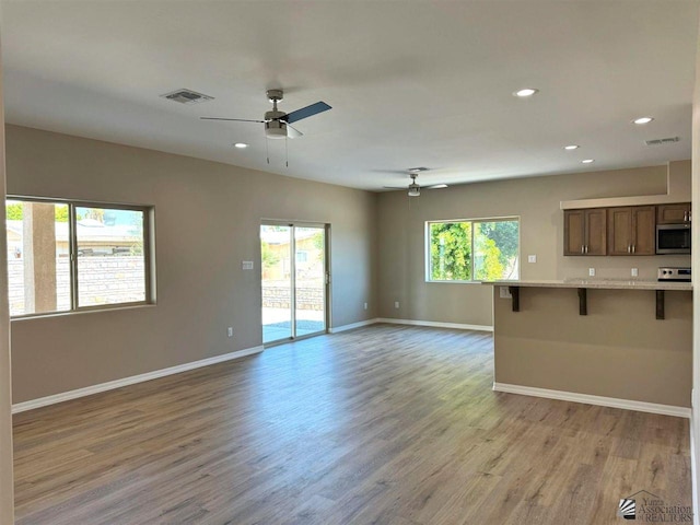 unfurnished living room with ceiling fan and light hardwood / wood-style flooring