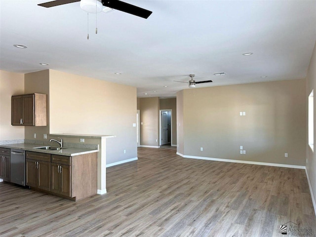 kitchen with dishwasher, sink, ceiling fan, and light hardwood / wood-style flooring