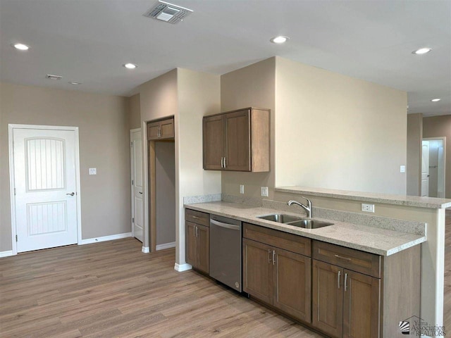 kitchen featuring sink, stainless steel dishwasher, kitchen peninsula, light stone countertops, and light wood-type flooring