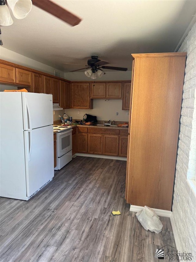 kitchen featuring white appliances, dark wood-type flooring, sink, ceiling fan, and brick wall