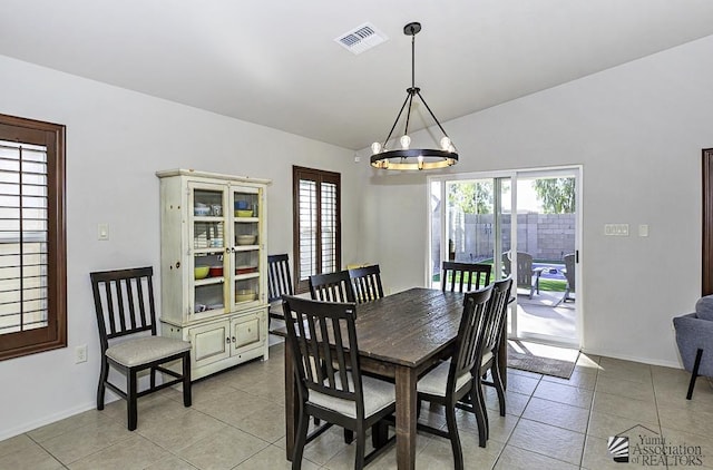 dining area with light tile patterned floors and an inviting chandelier