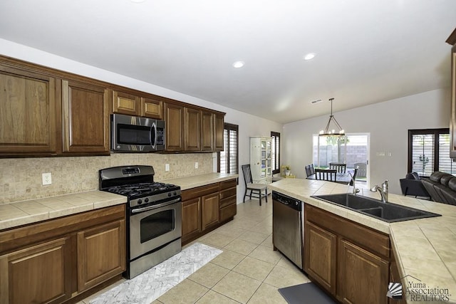 kitchen with tile countertops, sink, appliances with stainless steel finishes, and tasteful backsplash