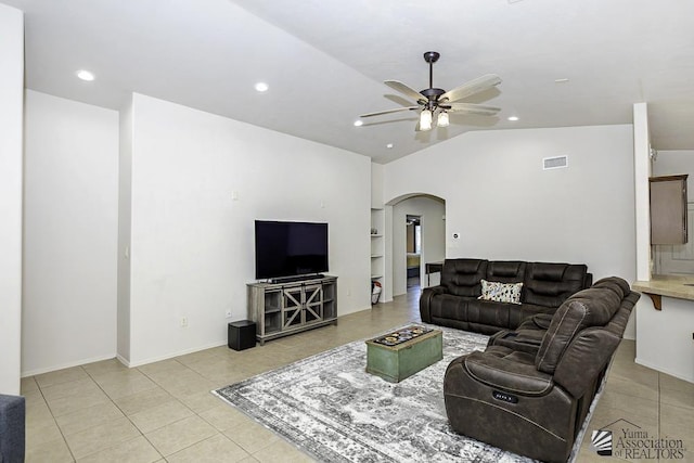 tiled living room featuring built in shelves, vaulted ceiling, and ceiling fan