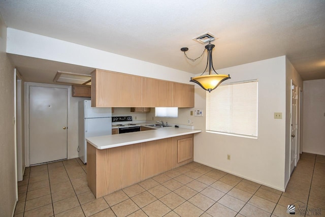 kitchen with pendant lighting, sink, electric range oven, kitchen peninsula, and white fridge