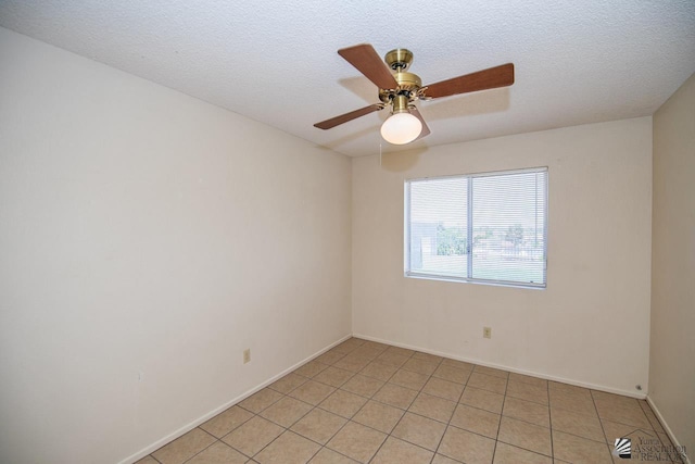 tiled empty room featuring ceiling fan and a textured ceiling