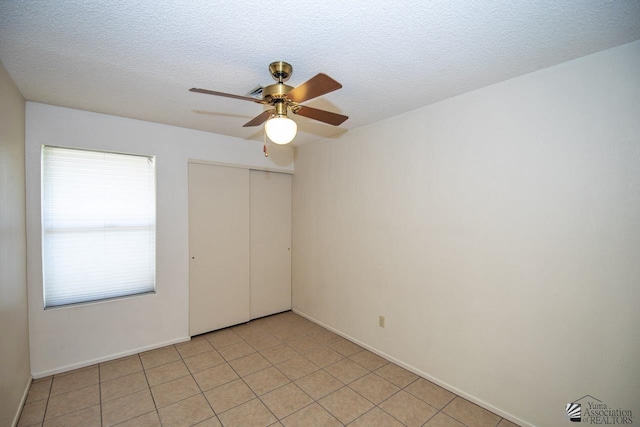 tiled spare room featuring ceiling fan and a textured ceiling