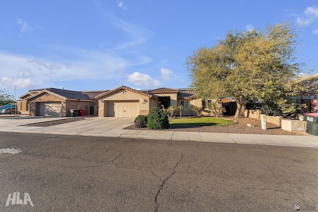 mediterranean / spanish home with a garage, a tile roof, driveway, and stucco siding