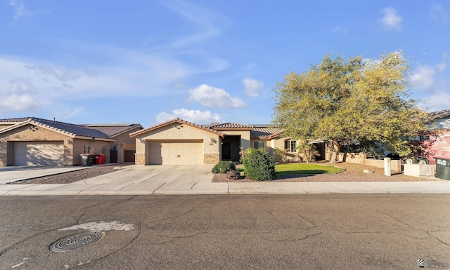 mediterranean / spanish house with concrete driveway, a tiled roof, an attached garage, and stucco siding