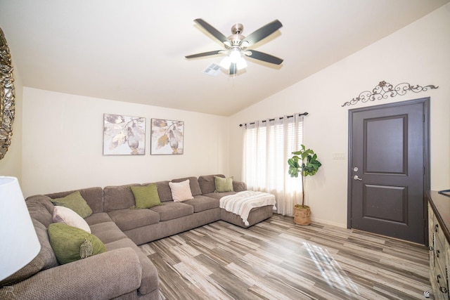 living room featuring ceiling fan, light wood-type flooring, and vaulted ceiling