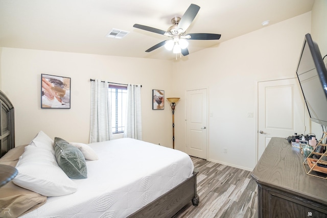 bedroom featuring ceiling fan, light wood-type flooring, and lofted ceiling