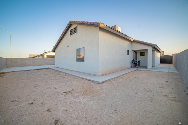 back house at dusk with a patio area