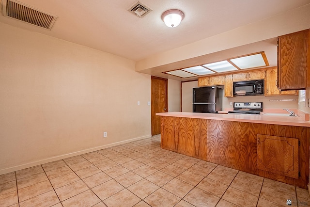 kitchen featuring sink, kitchen peninsula, light tile patterned floors, and black appliances