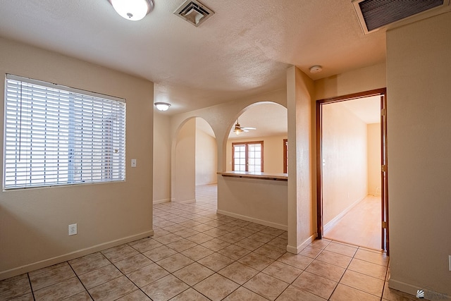 unfurnished room with light tile patterned floors, a textured ceiling, and ceiling fan