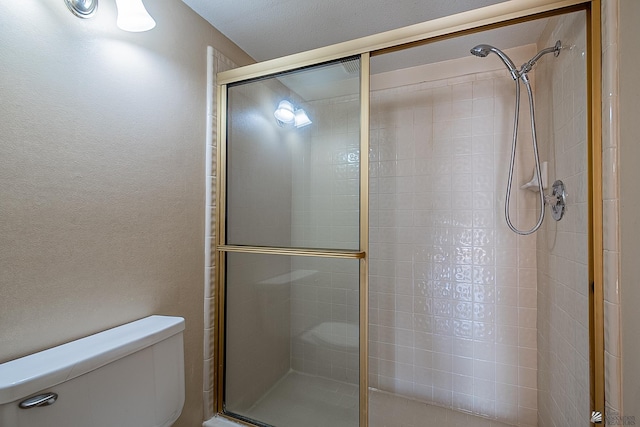 bathroom with toilet and a shower with shower door