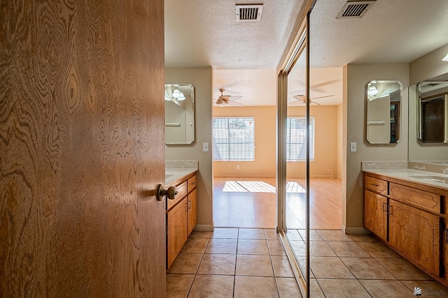 bathroom with ceiling fan, tile patterned floors, a textured ceiling, and vanity