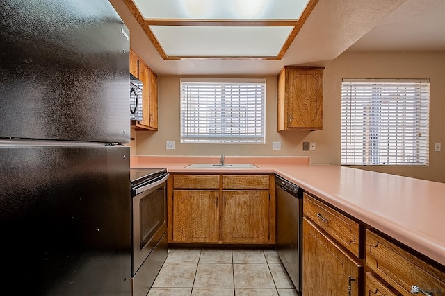 kitchen featuring light tile patterned flooring, sink, and black appliances