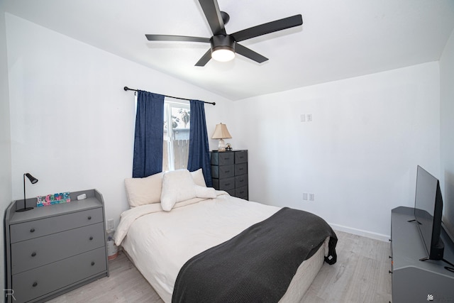 bedroom featuring ceiling fan, lofted ceiling, and light wood-type flooring