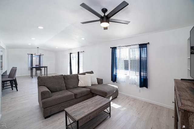 living room featuring ceiling fan, lofted ceiling, and light hardwood / wood-style flooring