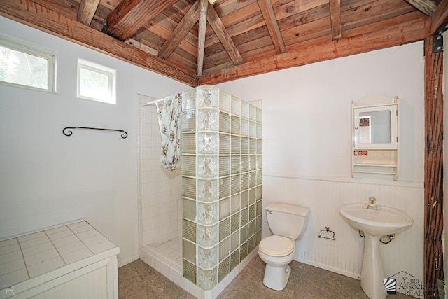 bathroom with a tile shower, vaulted ceiling with beams, toilet, and wood ceiling