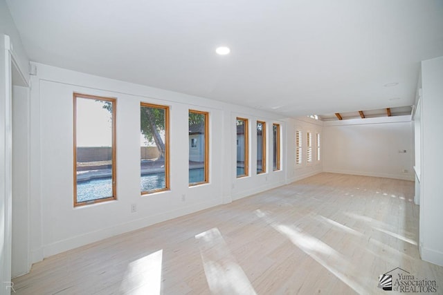 empty room with recessed lighting, light wood-style flooring, and baseboards