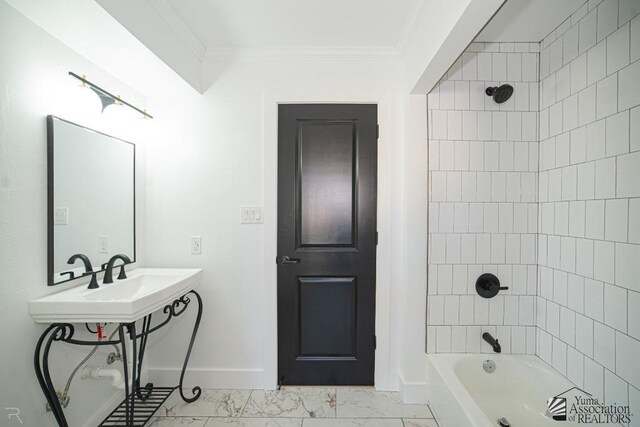 bathroom featuring shower / bath combination, a sink, baseboards, marble finish floor, and crown molding