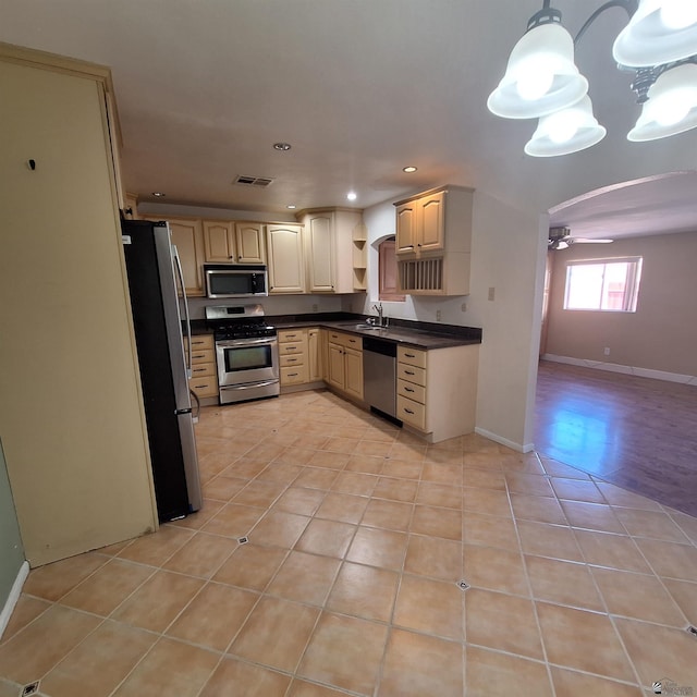 kitchen with ceiling fan, sink, decorative light fixtures, light tile patterned flooring, and appliances with stainless steel finishes