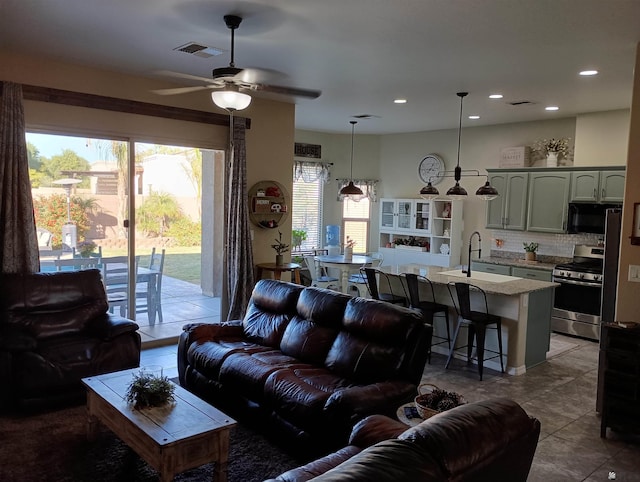 tiled living room featuring ceiling fan