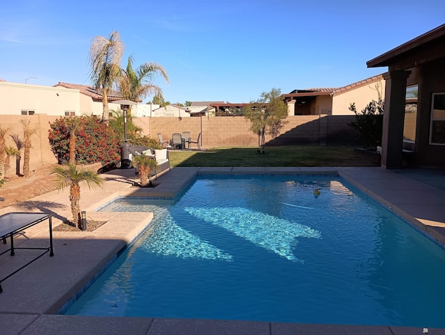 view of swimming pool with a yard and a patio area