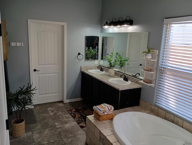 bathroom with tile patterned flooring, vanity, and a bath