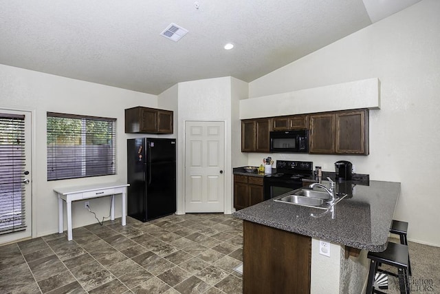 kitchen with a sink, lofted ceiling, black appliances, and dark brown cabinets