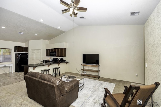 living area with visible vents, light colored carpet, and vaulted ceiling