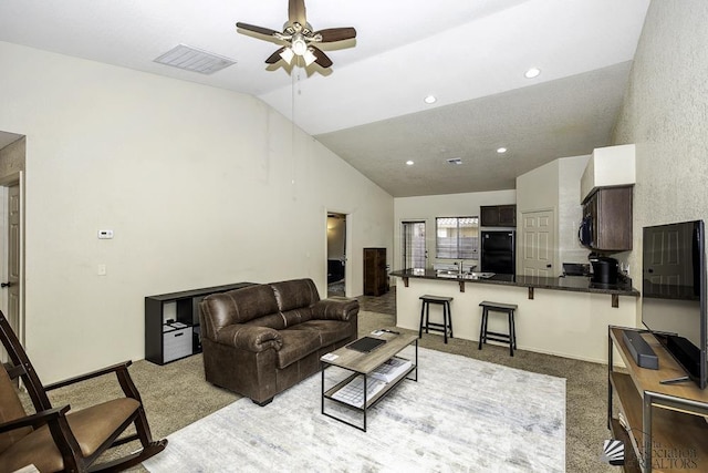 carpeted living room featuring visible vents, recessed lighting, baseboards, lofted ceiling, and ceiling fan