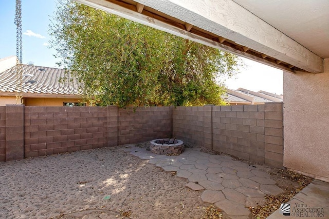 view of patio featuring an outdoor fire pit and a fenced backyard