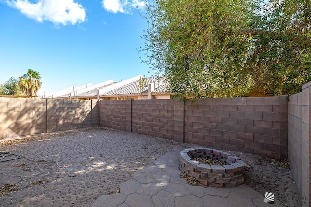 view of yard with a patio area, a fenced backyard, and an outdoor fire pit