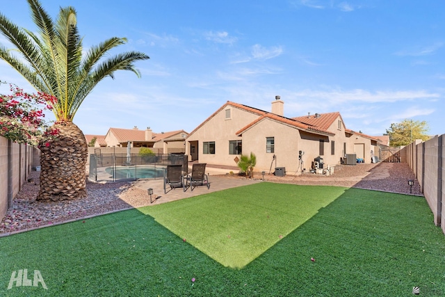 back of house featuring a fenced in pool, central AC, a lawn, and a patio area