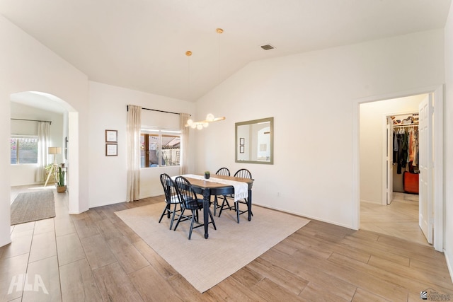 dining room with vaulted ceiling and light hardwood / wood-style flooring