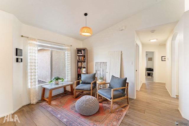 living area featuring vaulted ceiling and light hardwood / wood-style flooring