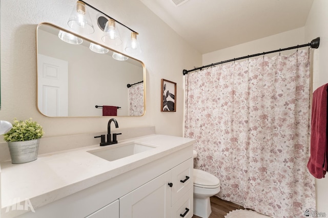 bathroom featuring vanity, hardwood / wood-style floors, and toilet