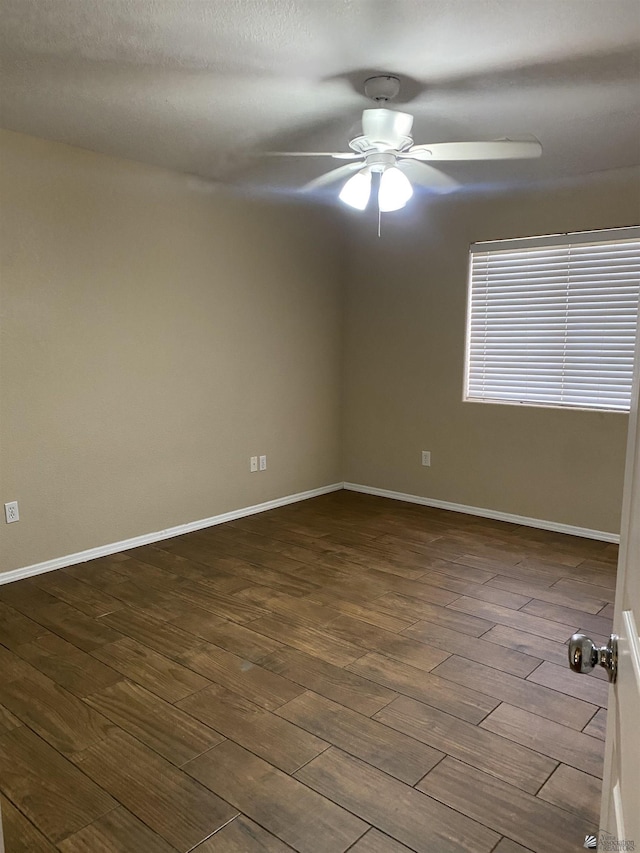 spare room featuring ceiling fan and dark wood-type flooring