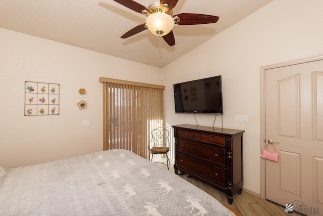 bedroom featuring ceiling fan, light wood-type flooring, and vaulted ceiling